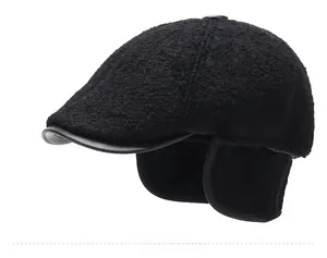 Detail view of winter black flat cap with ear flaps and premium leather brim binding
