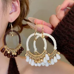 Bohemian cotton-wrapped drop hoop earrings with fringe beads shown on model