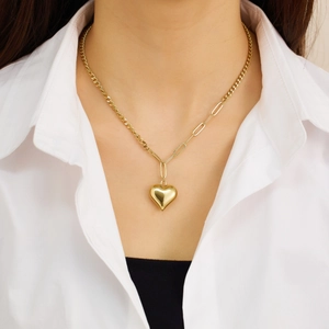 Collar con colgante de corazón dorado y cadena de eslabones mixtos en una modelo