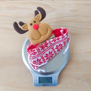Detail of knitted Christmas reindeer gift bag with 3D plush nose and 42g lightweight design