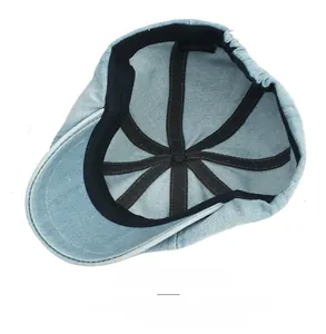 Detail of light blue denim baker boy hat interior with elastic band and cotton label