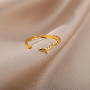Detail of rose gold Arabic love ring featuring crystal accents on beige silk fabric