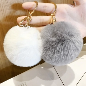 Detailed close-up of fluffy leopard print heart pompom keychain with metal hardware