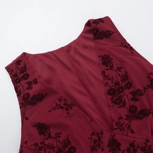 Detail of the V-neck and intricate burgundy flocked floral pattern on a slim-fit mesh dress