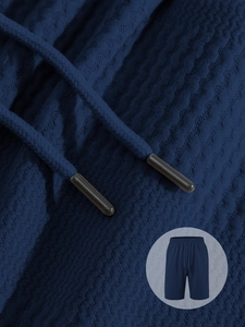 Close-up of navy blue waffle texture fabric and drawstring detail on men's casual shorts
