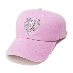 Macro shot of pink washed cotton baseball cap with glittering rhinestone heart pattern