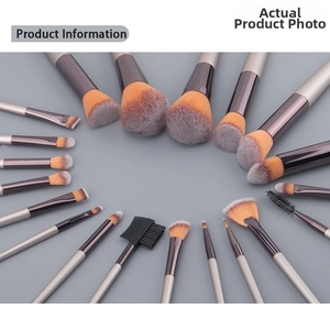 Flat lay of champagne-colored makeup brushes set with orange and grey fiber bristles