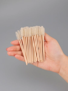 Close-up of disposable eyelash brushes with pink handles and white spiral heads
