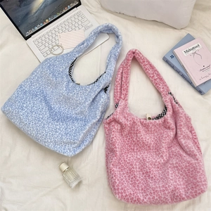 Detail view of pink and blue leopard print faux fur tote bags with soft plaid lining