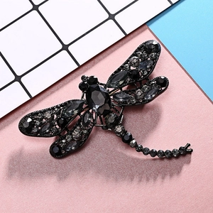 Detail of vintage dragonfly brooch featuring black plating and dark grey crystals
