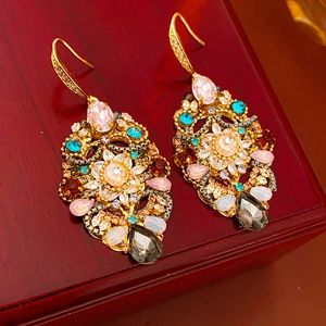 Close-up of Baroque vintage drop earrings with colorful crystals on a red jewelry box