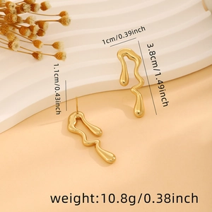 Detailed view of wavy gold earrings with dimensions and weight on soft beige background