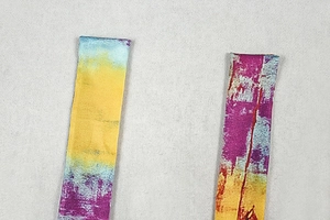 Gros plan des bretelles en tissu imprimé tie-dye sur une robe trapèze sans manches