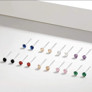 Macro view of 9 pairs colorful zircon stud earrings set on a clean white background