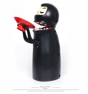 Detailed side view of the Kaonashi No-Face automatic coin bank with a red tray on white background