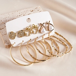 Détail d'un ensemble de boucles d'oreilles dorées avec strass et perles sur soie