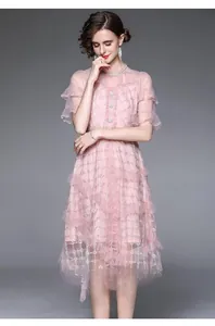 Détail macro d'une robe rose à dentelle avec broderie dorée et col perlé élégant