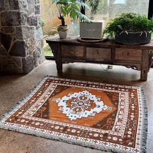 Bohemian woven camping blanket with caramel geometric patterns and tassel edges detail