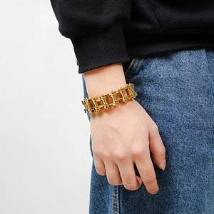 Detailed close-up of a gold-toned men's punk rock hollow cross bike chain bracelet on wrist