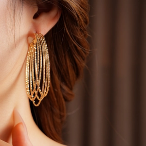 Close-up of elegant gold layered hoop earrings worn by a model for a stylish look