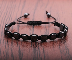 Macro shot of adjustable braided bracelet with polished square hematite beads