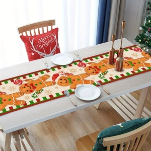 Top view of a festive linen table runner with gingerbread man and candy cane prints