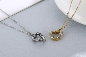 Detailed view of silver and gold irregular heart pendants with sparkling rhinestones