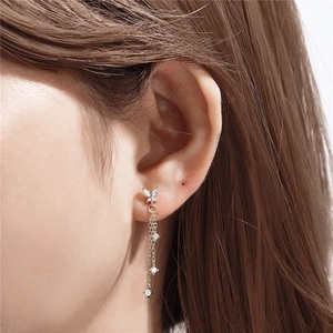 Macro shot of silver sterling butterfly tassel earrings with sparkling gemstones