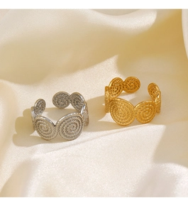 Detail view of gold and silver spiral rings on silk fabric showing the hollow open design