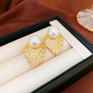 Close-up of fan-shaped leaf earrings with white pearls and zircons in a jewelry box