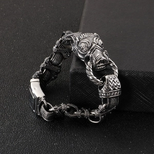 Detailed view of punk rock boar head charm and thick woven link steel bracelet
