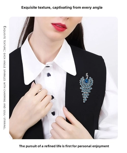 Detail of elegant peacock brooch with blue crystals pinned on a black suit vest