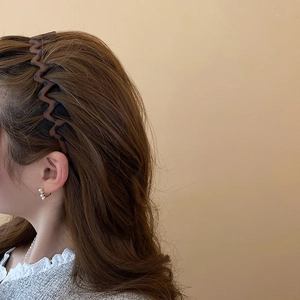 Close-up of wavy leopard print headband in brown tortoiseshell on model's hair