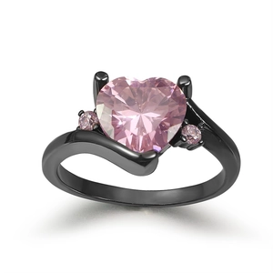Detail of black gold ring featuring a heart shaped pink zircon and side stones