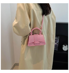 Sac à main trapèze rose tressé avec poignée et bandoulière sur trench-coat beige