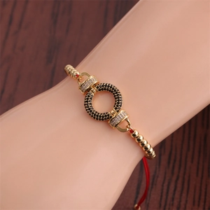 Detailed view of adjustable red rope bracelet with colorful zircon ring charm on a wrist