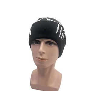 Black knit beanie featuring white skeleton hand patterns for autumn and winter warmth