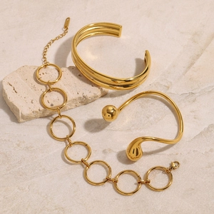 Detailed shot of three gold-plated stainless steel bracelets on natural stone props