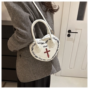 Borsa bianca a cuore con fiamme nere e croce rossa indossata dalla modella urbana