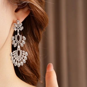 Gros plan de boucles d'oreilles vintage à pampilles en argent et zircons sur mannequin