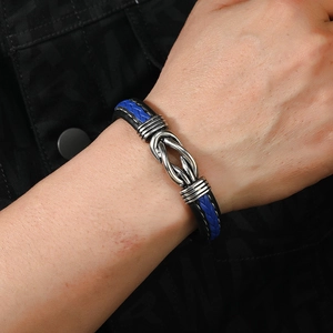 Detail of woven leather bracelet in blue and black with silver knot magnetic clasp