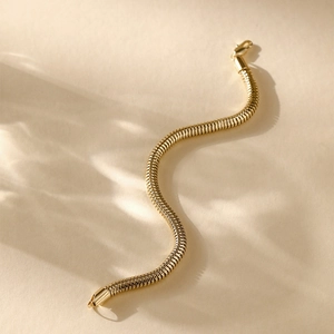 Detail of 14K gold plated snake bone chain bracelet with elegant light and shadow effects