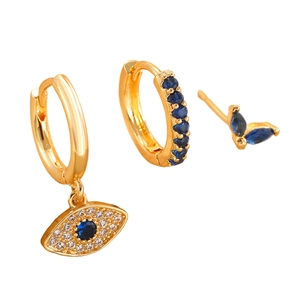 Detail of gold evil eye earring set featuring blue cubic zirconia and butterfly stud