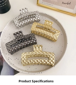 Detail of four metallic claw clips with diamond patterns in silver and gold finishes