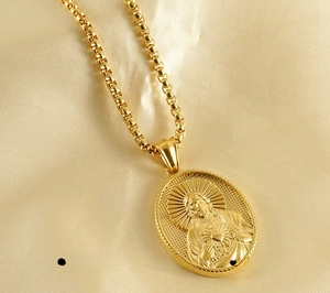 Detail of 18K gold stainless steel necklace with Sacred Heart of Jesus oval pendant
