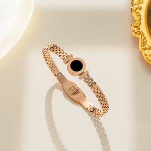 Rose gold stainless steel bracelet featuring roman numerals and a black shell disc