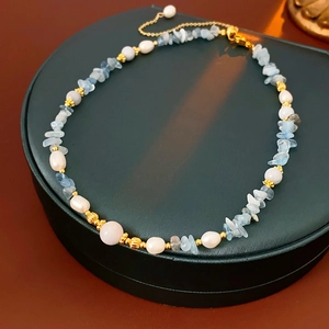 Detail of freshwater pearl necklace with aquamarine stones and gold extender chain