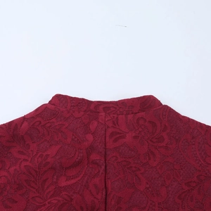 Dettaglio macro del colletto in pizzo rosso scuro e motivi floreali del vestito