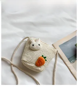 Detail der Kinder Strohtasche mit süßem 3D-Hasen und Karotten-Dekor auf beigem Stoff