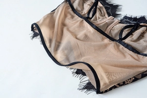Macro shot of delicate black eyelash lace and nude mesh fabric on the seamless bra